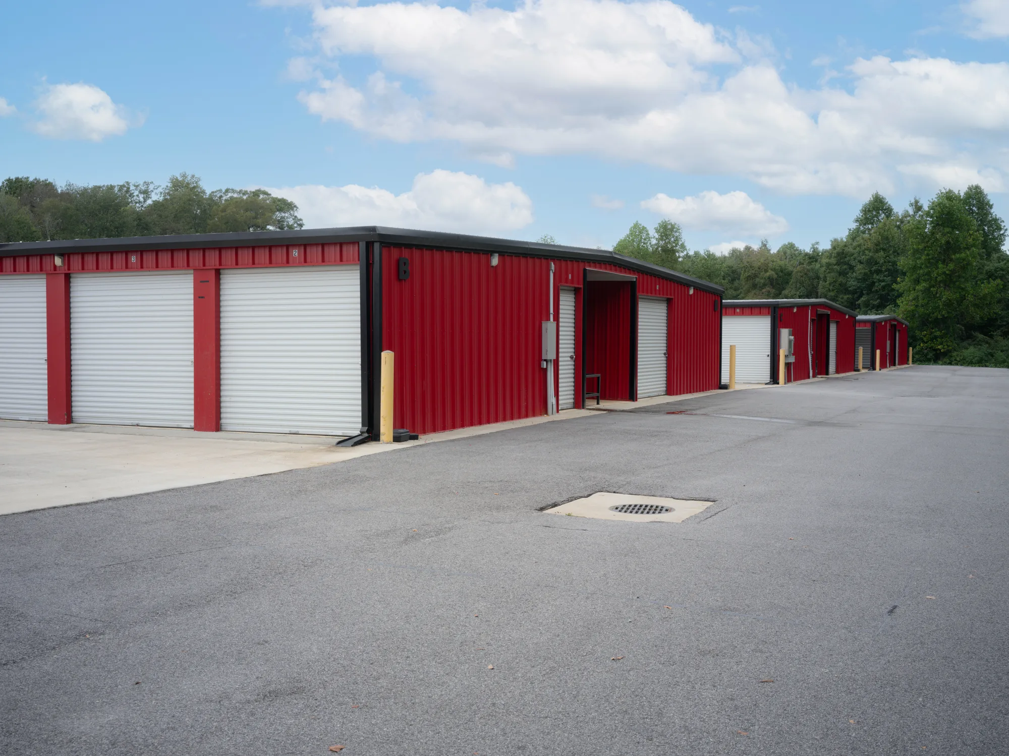 White roll-up doors in red steel frames along a row of self-storage buildings